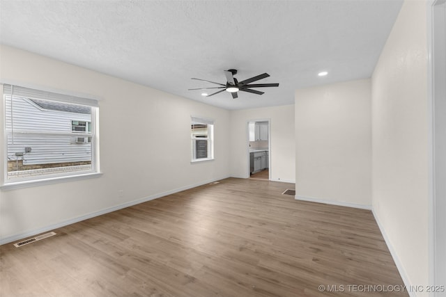 524 W 18th, Ada, OK 74820 - unfurnished living room with healthy amount of natural light, wood finished floors, ceiling fan, baseboards, and recessed lighting