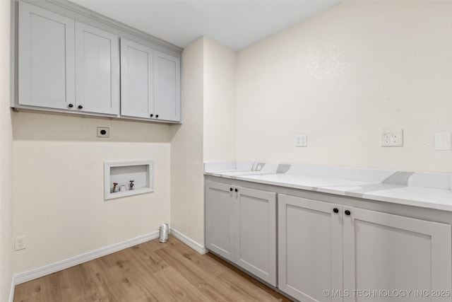 524 W 18th, Ada, OK 74820 - laundry area with electric dryer hookup, light wood finished floors, washer hookup, cabinet space, and baseboards