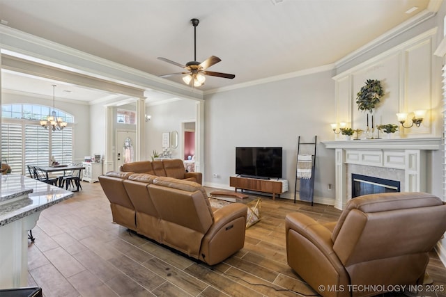 1631 Augusta, Ada, OK 74820 - living area featuring a chandelier, wood finished floors, crown molding, ceiling fan, and a glass covered fireplace
