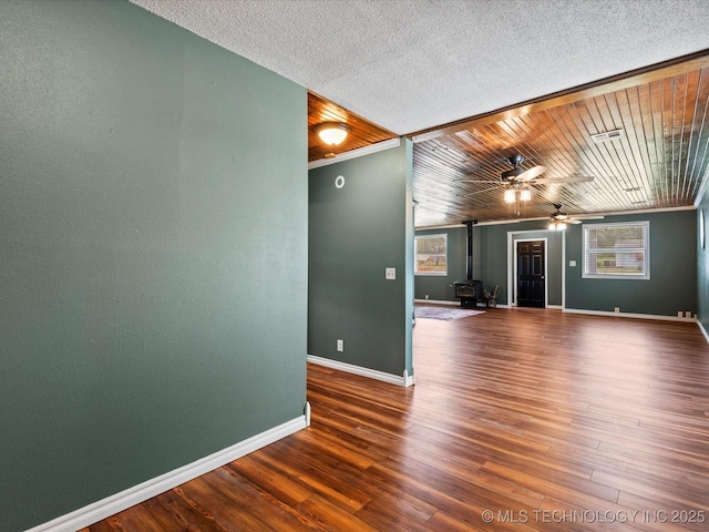324 2019th Rd, Bartlesville, OK 74003 - spare room with a wood stove, ceiling fan, baseboards, and wood finished floors
