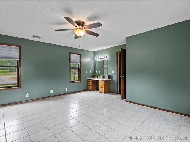 324 2019th Rd, Bartlesville, OK 74003 - empty room featuring ceiling fan, a textured ceiling, light tile patterned floors, and baseboards