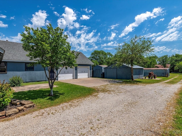 324 2019th Rd, Bartlesville, OK 74003 - view of front of house featuring driveway, roof with shingles, a garage, and a front lawn