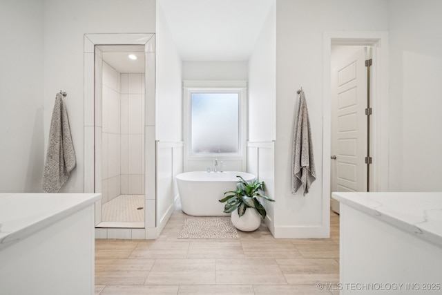 1038 E 38th Pl, Tulsa, OK 74105 - bathroom featuring a freestanding tub, vanity, a shower stall, wood finished floors, and wainscoting