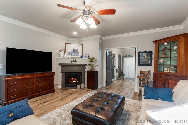 7724 S 83rd E Ave, Tulsa, OK 74133 - living area featuring crown molding, a ceiling fan, wood finished floors, a lit fireplace, and baseboards