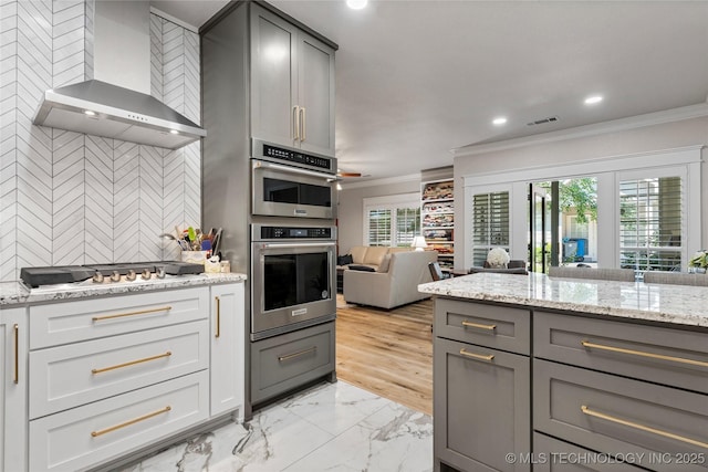 7724 S 83rd E Ave, Tulsa, OK 74133 - kitchen with wall chimney exhaust hood, crown molding, gray cabinets, open floor plan, and stainless steel double oven