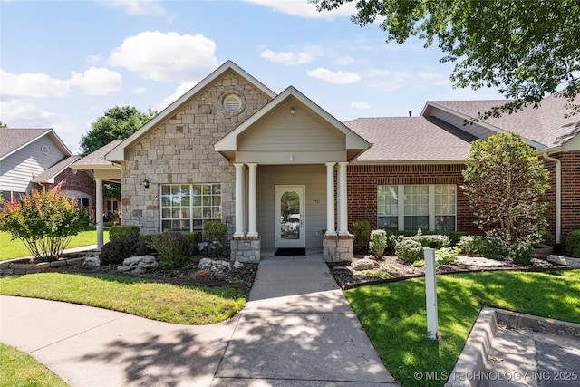 7724 S 83rd E Ave, Tulsa, OK 74133 - view of front of home featuring stone siding, a front lawn, a shingled roof, and brick siding