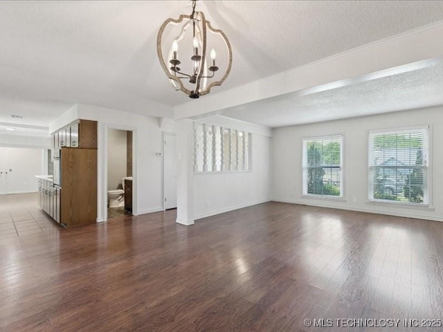 5339 S 32nd W Ave, Tulsa, OK 74107 - unfurnished living room featuring a chandelier, baseboards, dark wood-style floors, and a textured ceiling