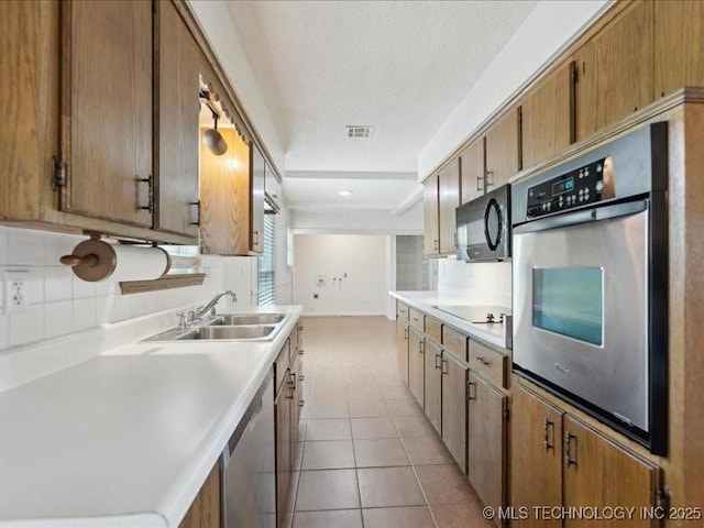 5339 S 32nd W Ave, Tulsa, OK 74107 - kitchen with black appliances, a sink, backsplash, light countertops, and a textured ceiling