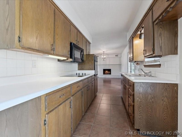 5339 S 32nd W Ave, Tulsa, OK 74107 - kitchen with black appliances, a sink, backsplash, and light countertops