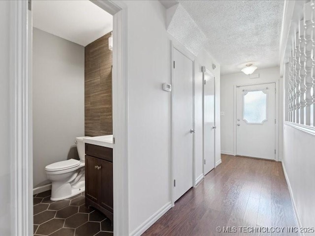 5339 S 32nd W Ave, Tulsa, OK 74107 - hall featuring a textured ceiling, dark wood-style floors, and baseboards