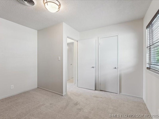 5339 S 32nd W Ave, Tulsa, OK 74107 - unfurnished bedroom with carpet, a textured ceiling, baseboards, and a closet