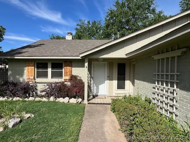 1800 N 26th St, Broken Arrow, OK 74014 - entrance to property featuring brick siding, a chimney, a lawn, and roof with shingles