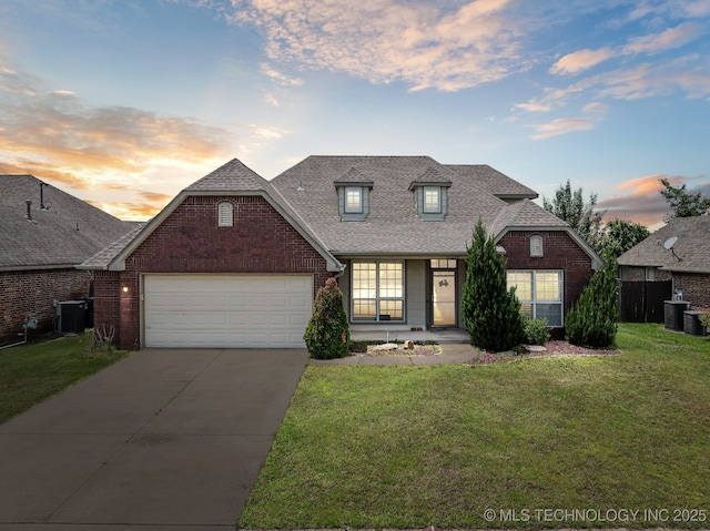 11210 N 131st E Pl, Owasso, OK 74055 - view of front facade with brick siding, an attached garage, central AC, a shingled roof, and concrete driveway