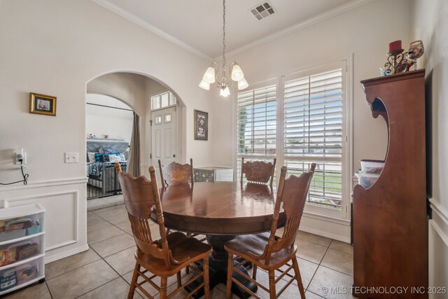 11210 N 131st E Pl, Owasso, OK 74055 - dining room featuring light tile patterned flooring, a chandelier, ornamental molding, plenty of natural light, and arched walkways