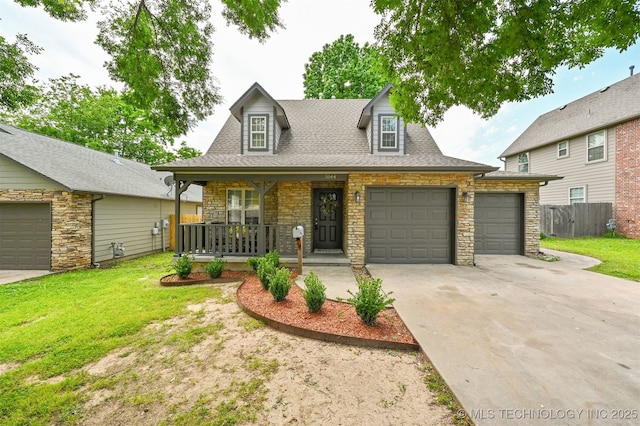 5144 S 34th W Ave, Tulsa, OK 74107 - view of front of home featuring stone siding, driveway, covered porch, and an attached garage