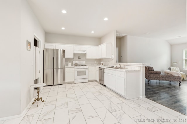 1309 W Missouri Ave, Claremore, OK 74019 - kitchen with appliances with stainless steel finishes, a sink, a peninsula, open floor plan, and light countertops