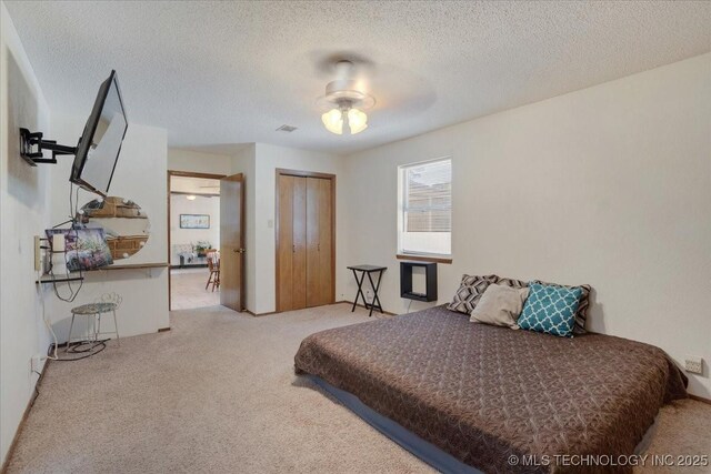 211 Meadowlark, Durant, OK 74701 - bedroom featuring carpet flooring, a closet, a textured ceiling, and a ceiling fan