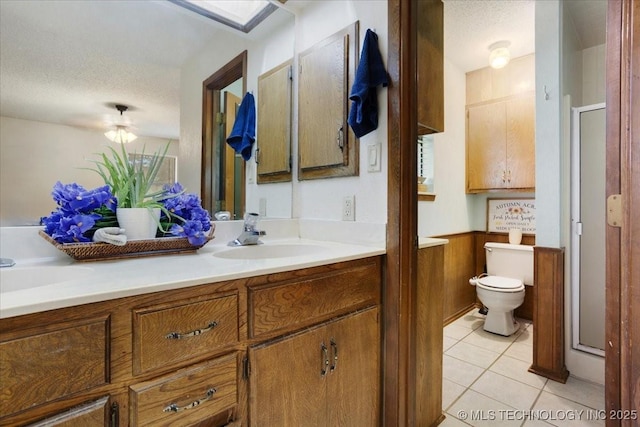 211 Meadowlark, Durant, OK 74701 - bathroom with double vanity, a textured ceiling, toilet, tile patterned floors, and a stall shower
