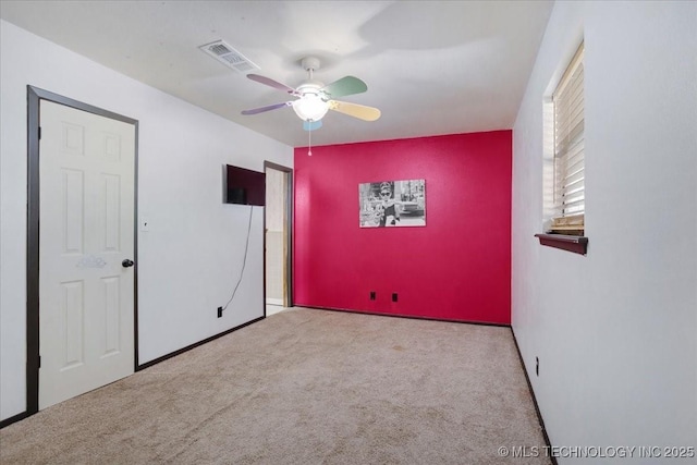 211 Meadowlark, Durant, OK 74701 - unfurnished bedroom featuring carpet, an accent wall, a ceiling fan, and baseboards
