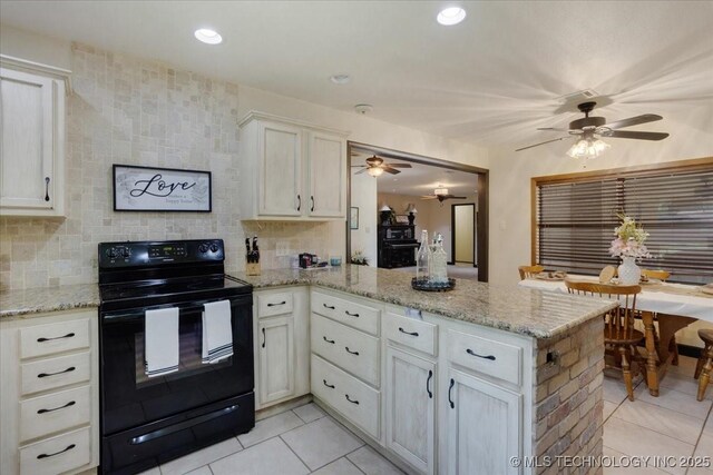 211 Meadowlark, Durant, OK 74701 - kitchen featuring black electric range oven, a ceiling fan, light tile patterned floors, a peninsula, and white cabinetry