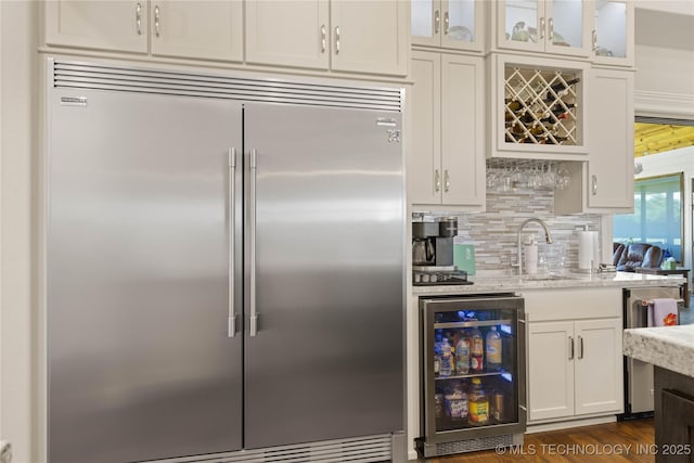 1580 Dawson Dr, Fort Gibson, OK 74434 - kitchen featuring stainless steel built in refrigerator, wine cooler, white cabinets, backsplash, and light stone countertops