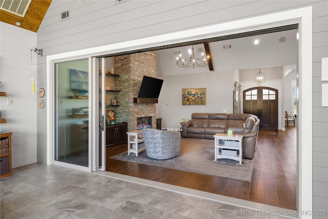 1580 Dawson Dr, Fort Gibson, OK 74434 - living area featuring high vaulted ceiling, a chandelier, wooden walls, a fireplace, and french doors