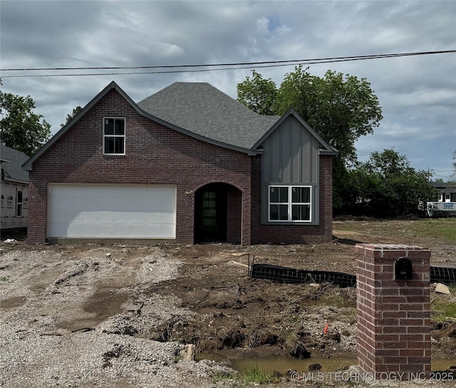 209 W Broadway St, Owasso, OK 74055 - view of front of property featuring brick siding, a garage, a shingled roof, and board and batten siding