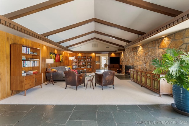 6232 S Jamestown Ave, Tulsa, OK 74136 - living room featuring stone tile floors, a fireplace, wooden walls, and carpet floors