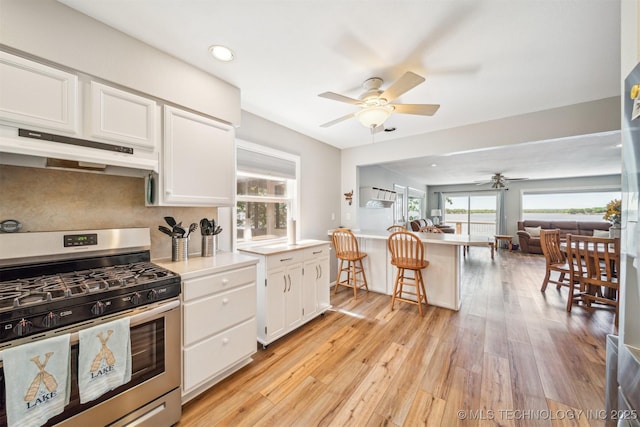 55890 E 315th Rd, Jay, OK 74346 - kitchen featuring stainless steel range with gas stovetop, under cabinet range hood, ceiling fan, white cabinetry, and open floor plan