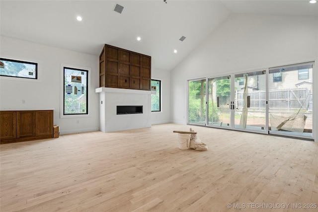 3917 S Madison Ave, Tulsa, OK 74105 - unfurnished living room featuring high vaulted ceiling, light wood finished floors, a fireplace, and recessed lighting