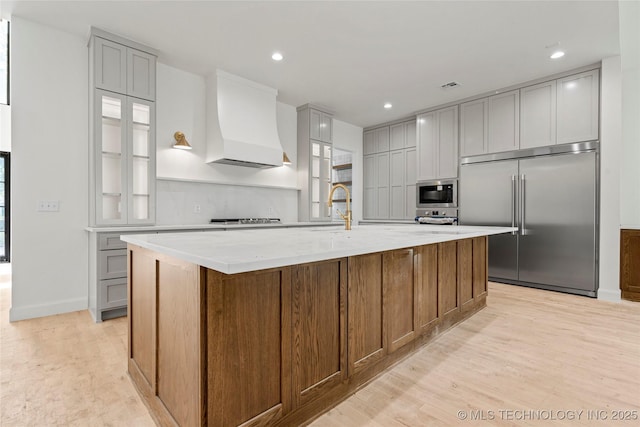 3917 S Madison Ave, Tulsa, OK 74105 - kitchen with built in appliances, custom exhaust hood, light wood-style flooring, a large island, and gray cabinets