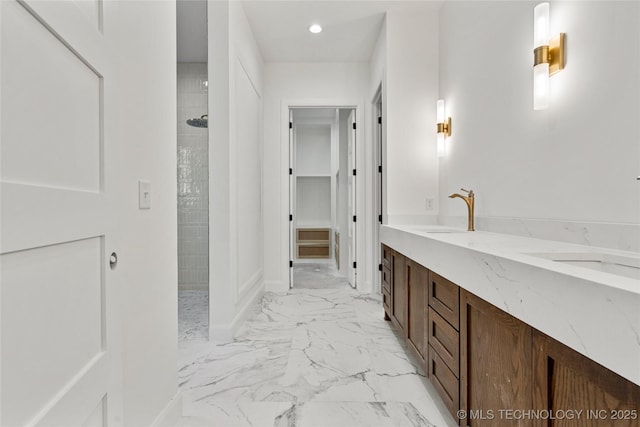 3917 S Madison Ave, Tulsa, OK 74105 - bathroom featuring walk in shower, marble look tile flooring, vanity, a spacious closet, and baseboards