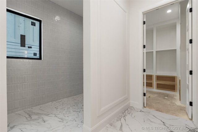 3917 S Madison Ave, Tulsa, OK 74105 - full bathroom with marble finish flooring, tiled shower, a walk in closet, and baseboards
