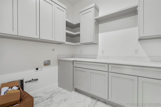 3917 S Madison Ave, Tulsa, OK 74105 - washroom with electric dryer hookup, cabinet space, baseboards, and light marble finish floors
