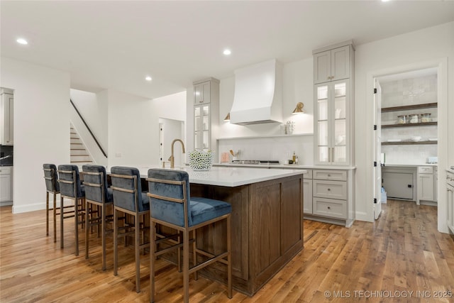 3917 S Madison Ave, Tulsa, OK 74105 - kitchen featuring premium range hood, a large island, light wood-style flooring, light countertops, and recessed lighting