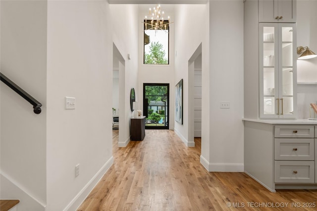 3917 S Madison Ave, Tulsa, OK 74105 - entrance foyer with a chandelier, light wood-type flooring, and a towering ceiling
