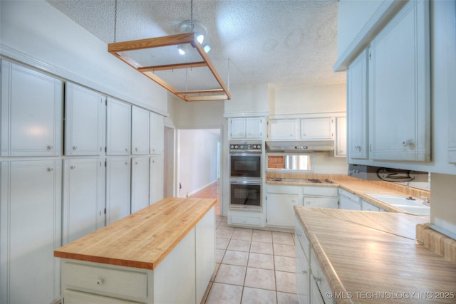 234 E Freeport St, Broken Arrow, OK 74012 - kitchen with multiple ovens, wooden counters, a textured ceiling, white cabinetry, and a sink