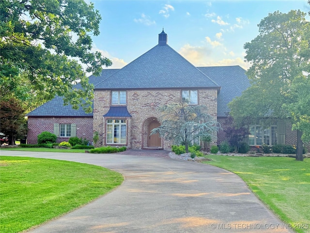 4224 S 69th W Ave, Tulsa, OK 74107 - view of front of property featuring a high end roof, a front lawn, brick siding, stone siding, and curved driveway