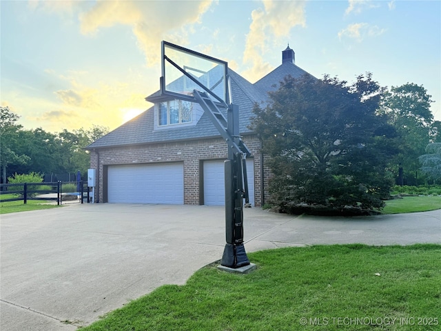 4224 S 69th W Ave, Tulsa, OK 74107 - property exterior at dusk featuring brick siding, concrete driveway, and a garage