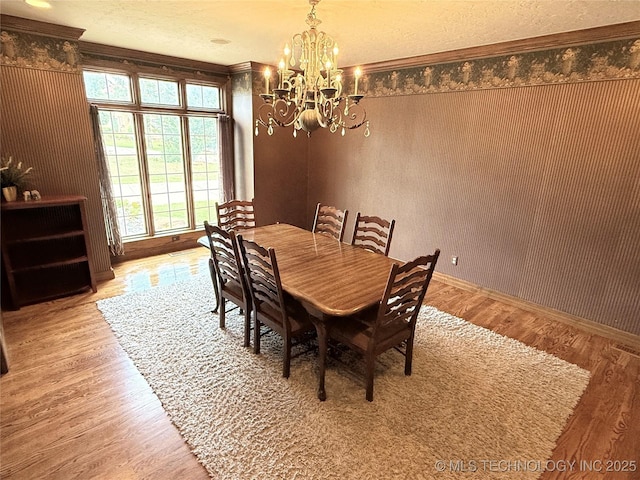 4224 S 69th W Ave, Tulsa, OK 74107 - dining space featuring a chandelier, wood finished floors, baseboards, and ornamental molding