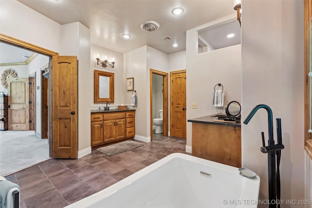 33268 Cardinal Dr, Afton, OK 74331 - bathroom featuring vanity, a bath, toilet, recessed lighting, and baseboards
