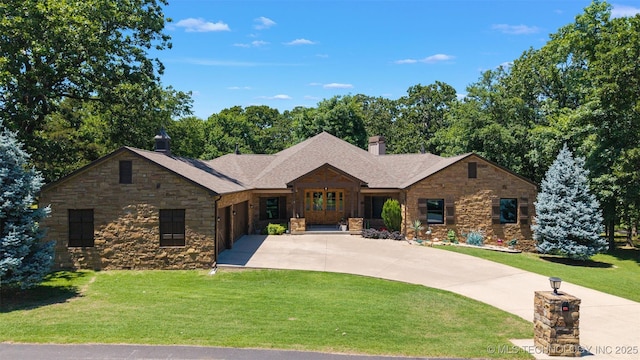 33268 Cardinal Dr, Afton, OK 74331 - view of front of house with driveway, stone siding, an attached garage, a front lawn, and a chimney