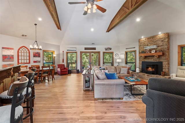 33268 Cardinal Dr, Afton, OK 74331 - living area with beam ceiling, a fireplace, light wood-style floors, ceiling fan, and a chandelier