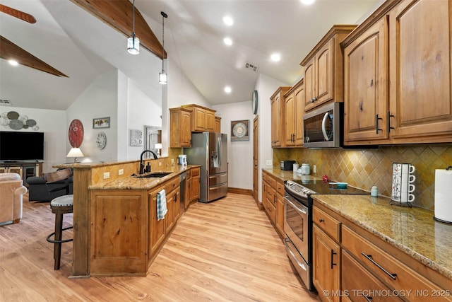 33268 Cardinal Dr, Afton, OK 74331 - kitchen featuring appliances with stainless steel finishes, a sink, open floor plan, a breakfast bar, and lofted ceiling