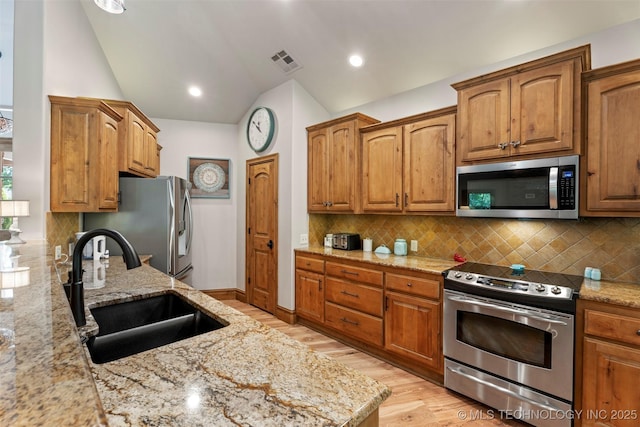 33268 Cardinal Dr, Afton, OK 74331 - kitchen with stainless steel appliances, a sink, lofted ceiling, light wood-style floors, and light stone counters