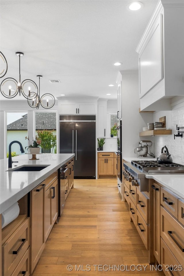 7408 E College St, Broken Arrow, OK 74014 - kitchen with appliances with stainless steel finishes, a sink, tasteful backsplash, light countertops, and decorative light fixtures