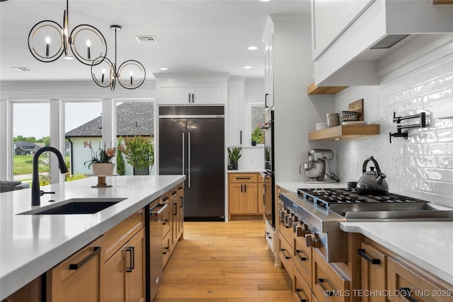 7408 E College St, Broken Arrow, OK 74014 - kitchen with appliances with stainless steel finishes, a sink, light countertops, tasteful backsplash, and light wood-type flooring