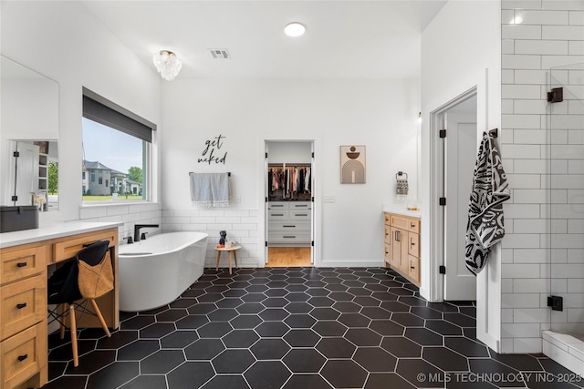 7408 E College St, Broken Arrow, OK 74014 - bathroom featuring vanity, a spacious closet, a shower stall, a soaking tub, and tile patterned floors