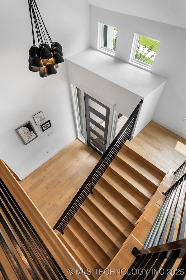 7408 E College St, Broken Arrow, OK 74014 - stairway featuring wood finished floors and a chandelier