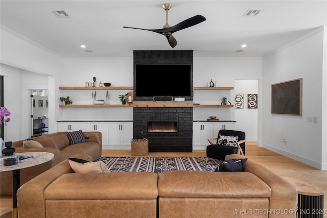 7408 E College St, Broken Arrow, OK 74014 - living room featuring light wood-style floors, crown molding, a ceiling fan, a brick fireplace, and recessed lighting